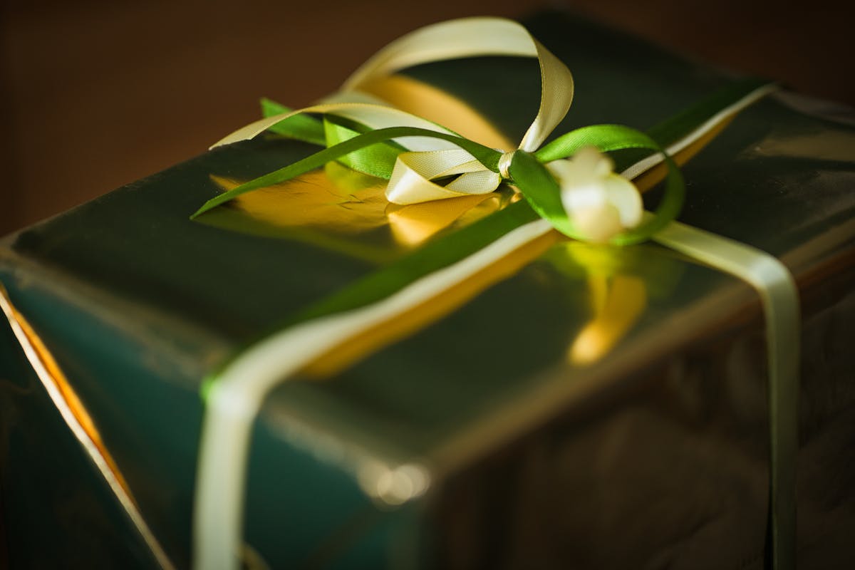 Wrapped gift box with green and gold ribbons
