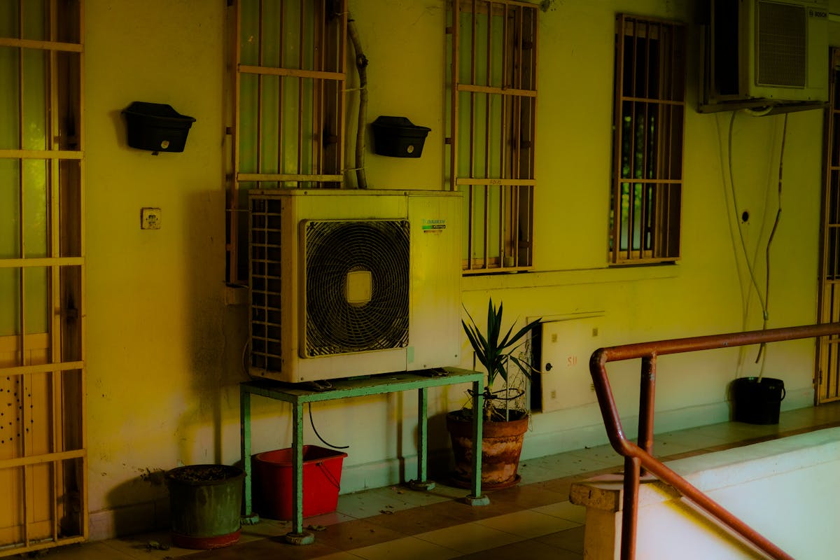 Air conditioning unit on a balcony with potted plants
