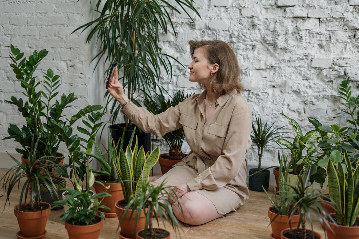 A woman surrounded by potted houseplants
