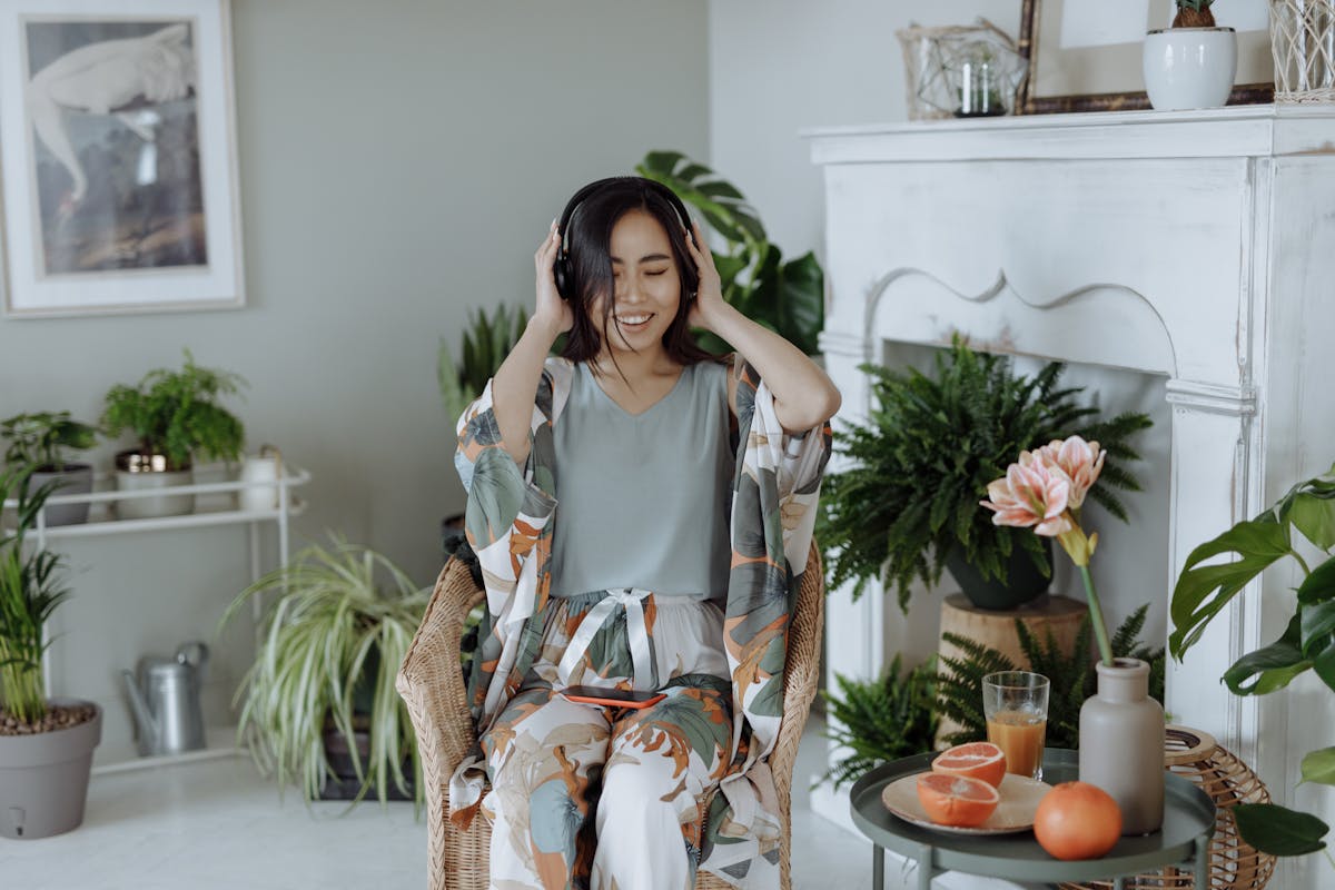 Relaxed woman with headphones surrounded by lush plants
