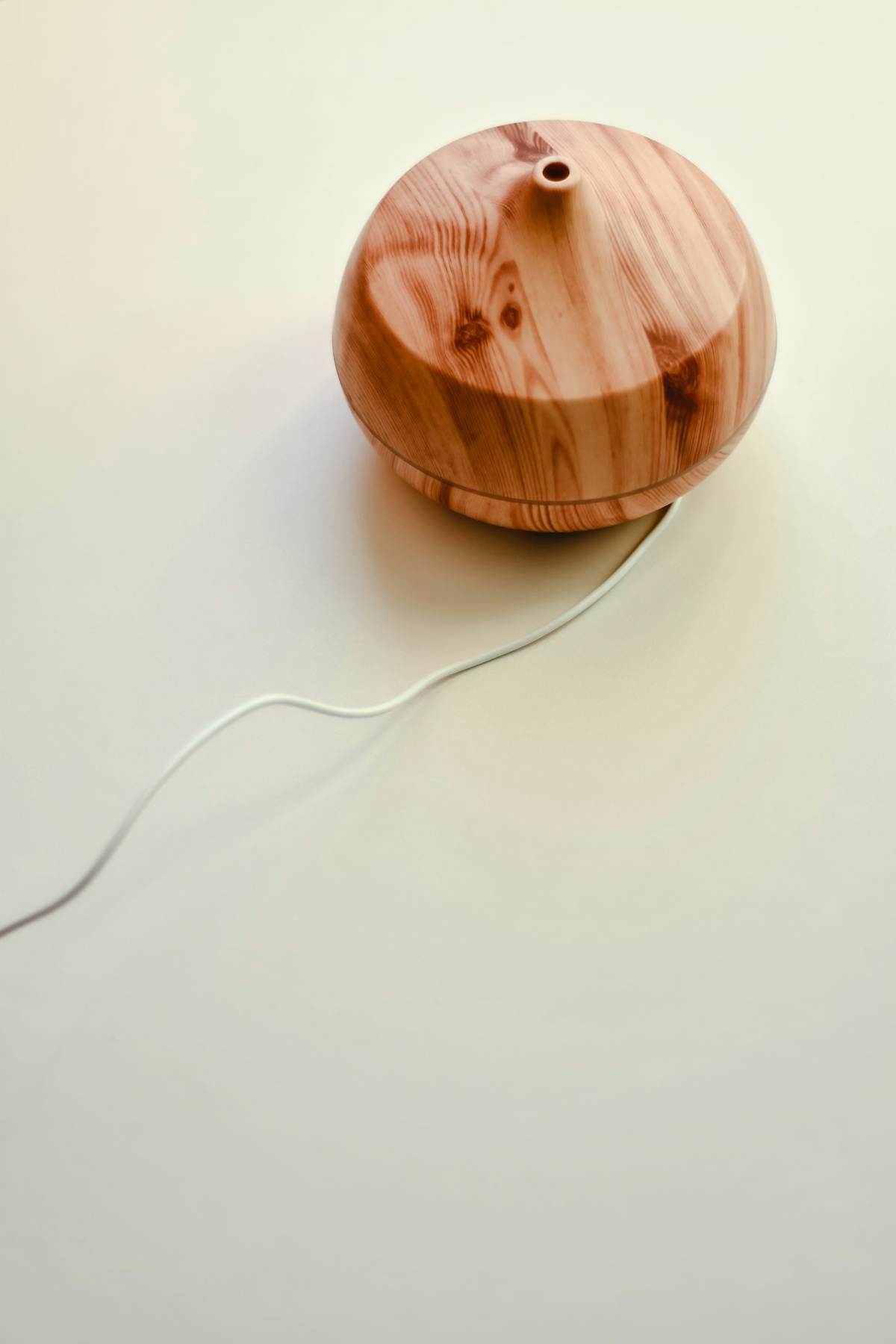A wooden essential oil diffuser on a white surface