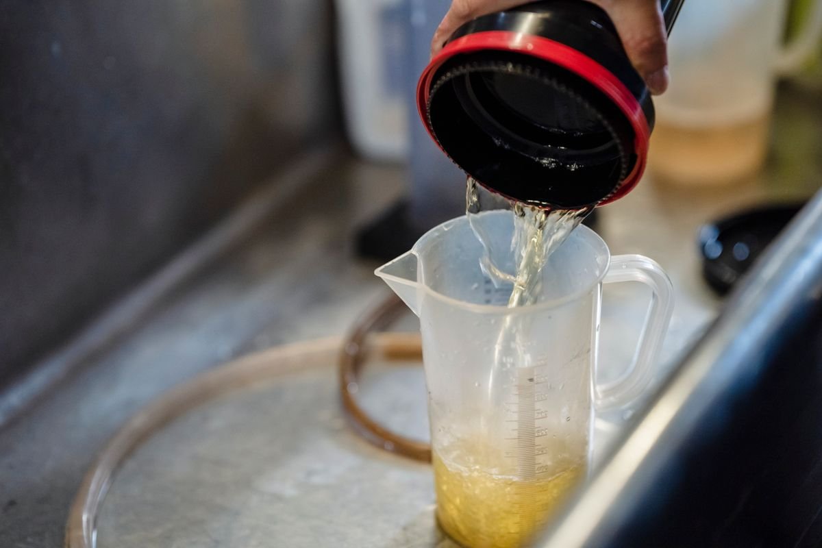 Water being poured precisely into a measuring cup, illustrating accurate fertiliser dilution