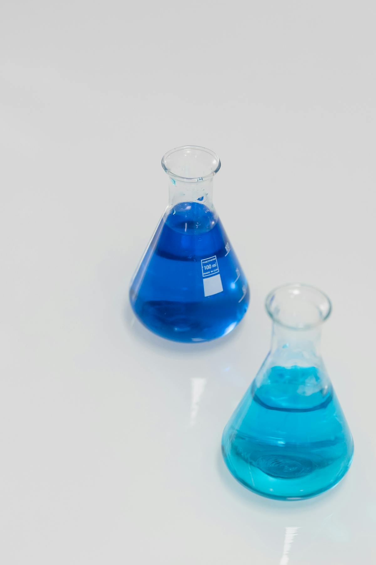 Erlenmeyer flasks in a laboratory setting representing chemical precision